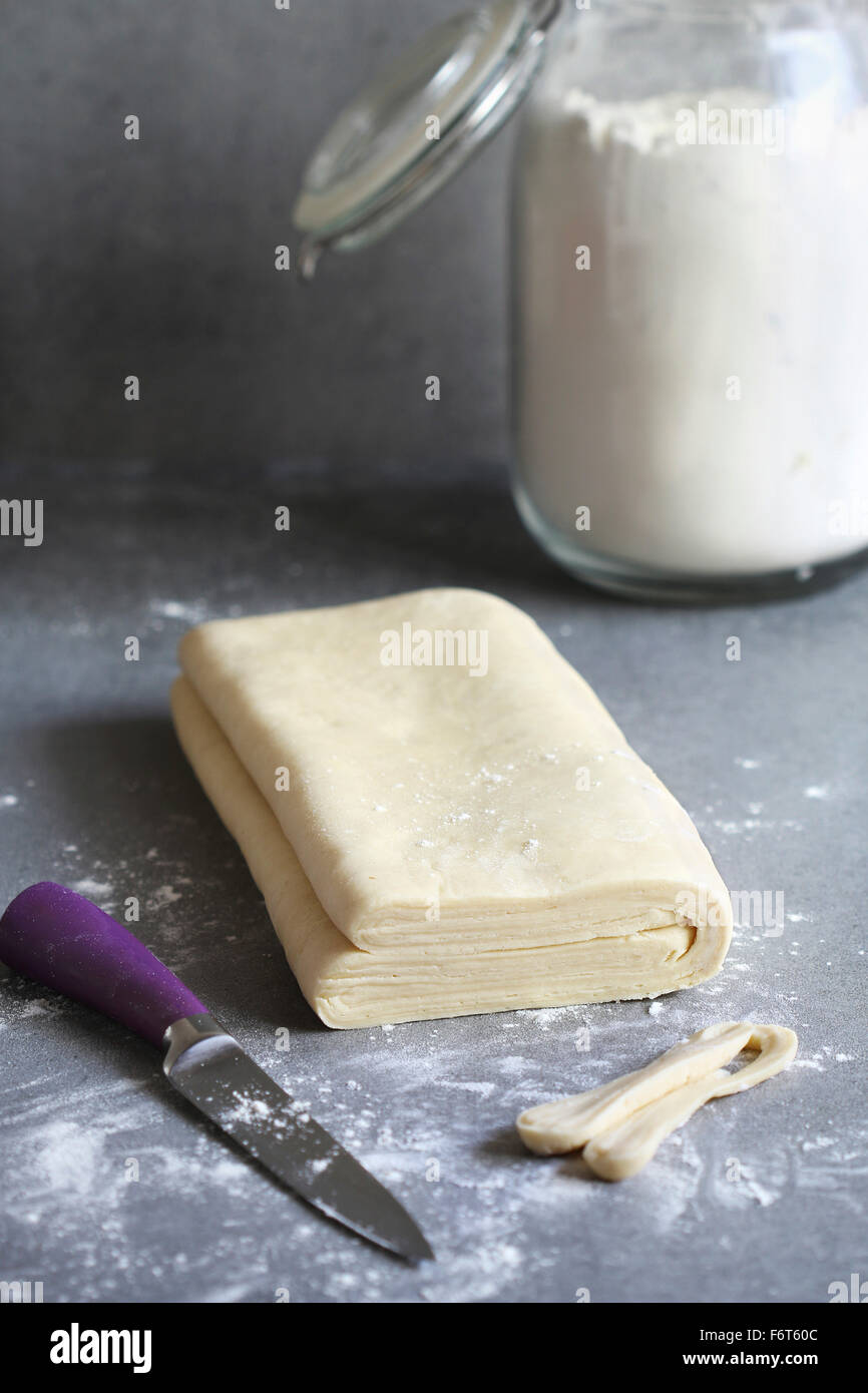 In casa della pasta sfoglia l'impasto su una superficie infarinata Foto Stock