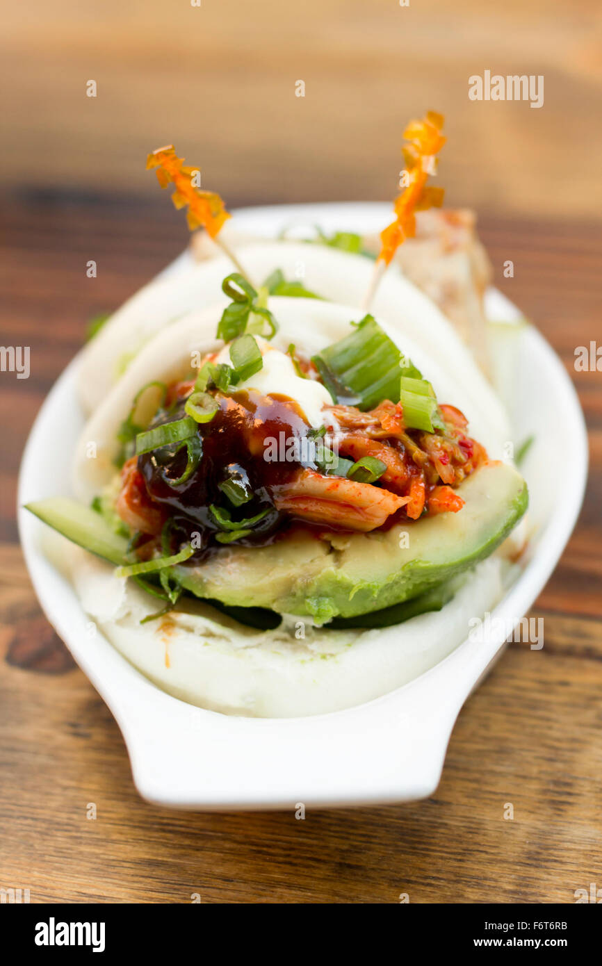 Coreano focacce cotte al vapore con pancetta di maiale avokado e kimchi Foto Stock