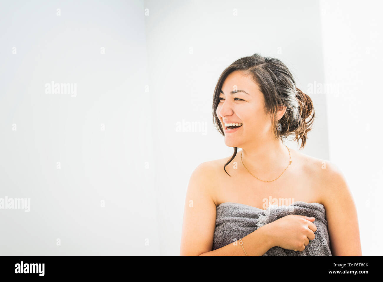 Ridendo donna avvolta in asciugamano Foto Stock