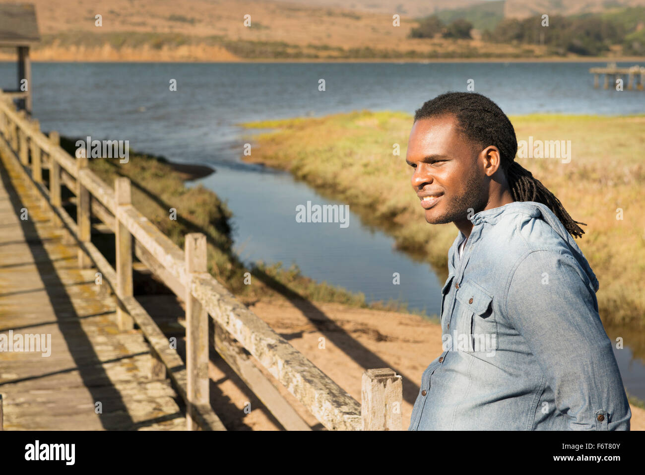 African American uomo in piedi sul ponte di legno Foto Stock