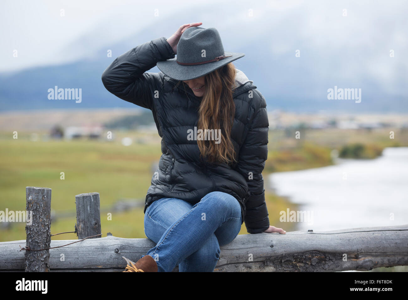 Caucasian donna seduta al fiume rurale Foto Stock