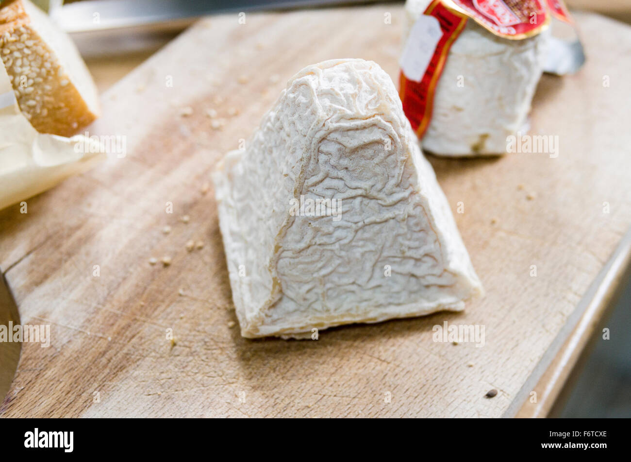 La buccia rugosa di un pezzo di Pouligny St Pierre formaggio. Un blocco di formaggio su un tagliere di legno. Foto Stock