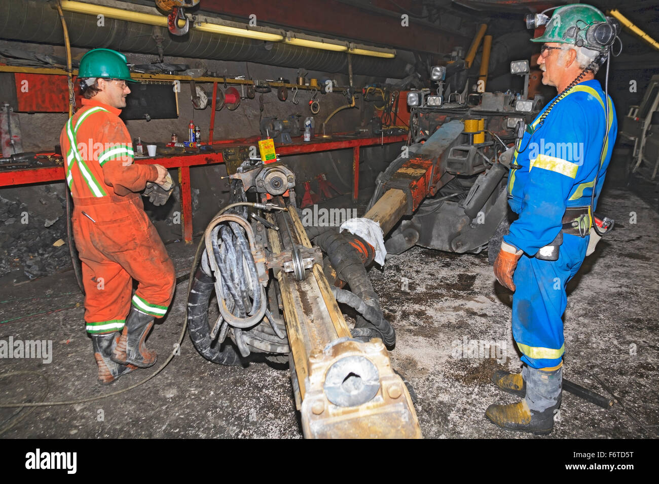 Lavoratori di miniera di riparazione di un Jumbo, un pezzo di foratura delle miniere, Eskay Creek miniera, area Iskut, British Columbia Foto Stock