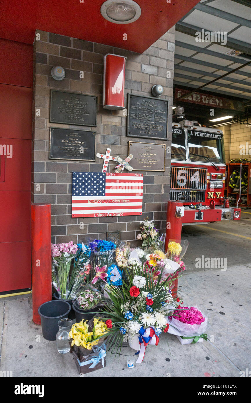 Fiori freschi al di fuori del motore 54 firehouse Ottava Avenue onore della società morti eroi che si estende dal 1870 al 9/11/2001 e oltre Foto Stock