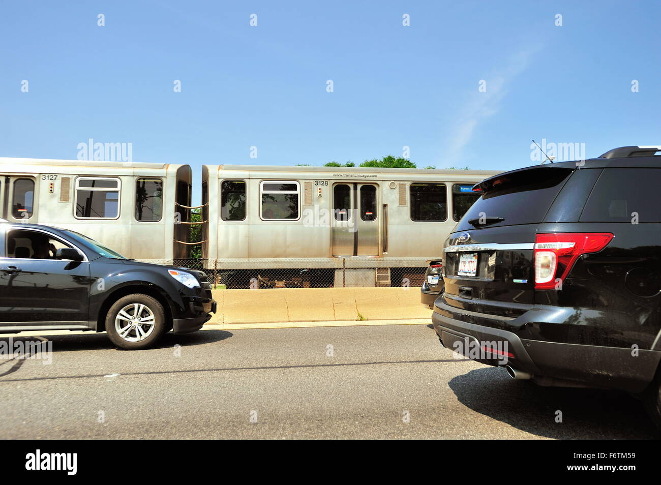 Una linea blu CTA Rapid Transit Train giunchi passato il traffico congestionato su Chicago del Kennedy Expressway. Chicago, Illinois, Stati Uniti d'America. Foto Stock