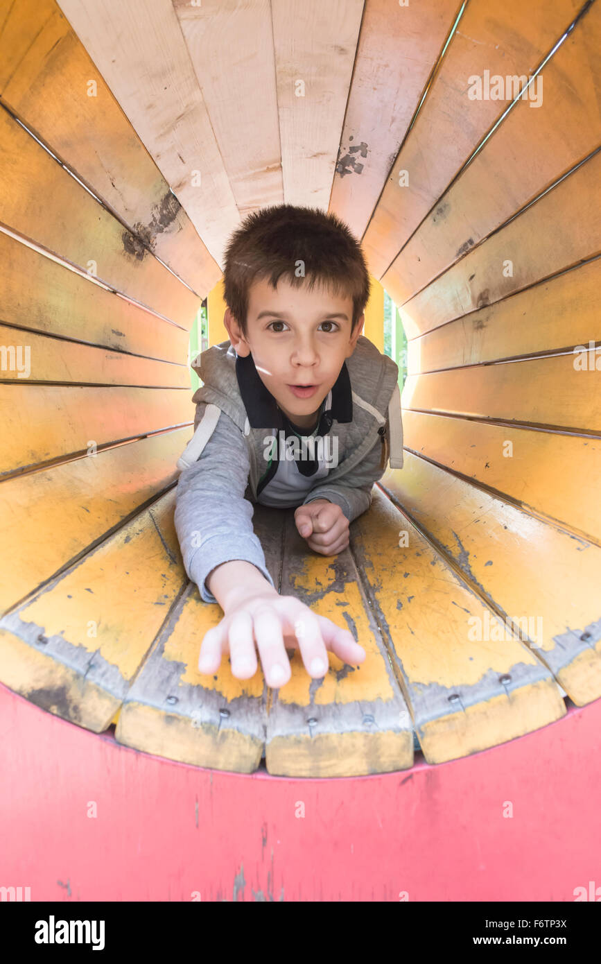Ragazzo in un tunnel al parco giochi Foto Stock