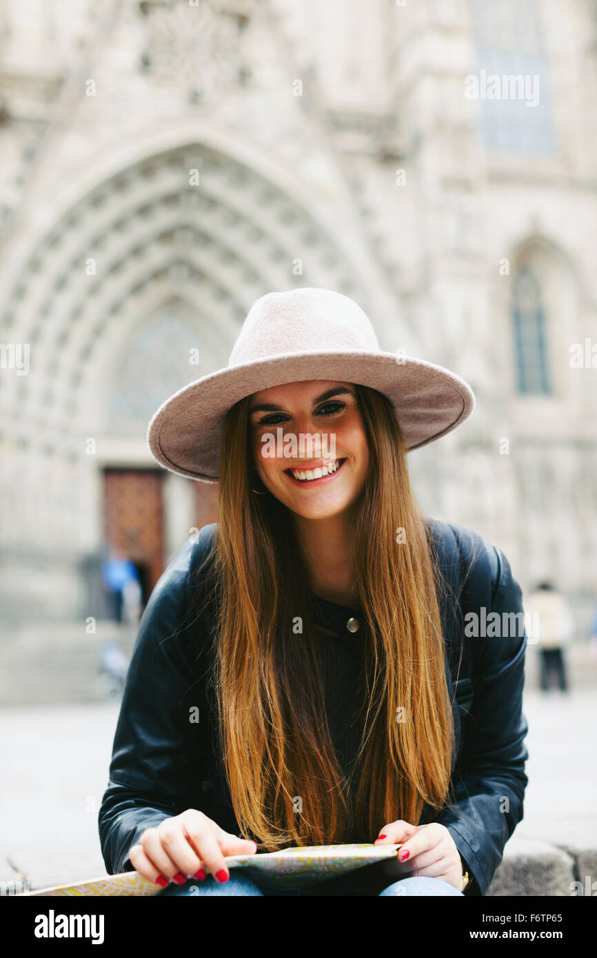 Spagna, Barcellona, ritratto di sorridente giovane donna con mappa Foto Stock
