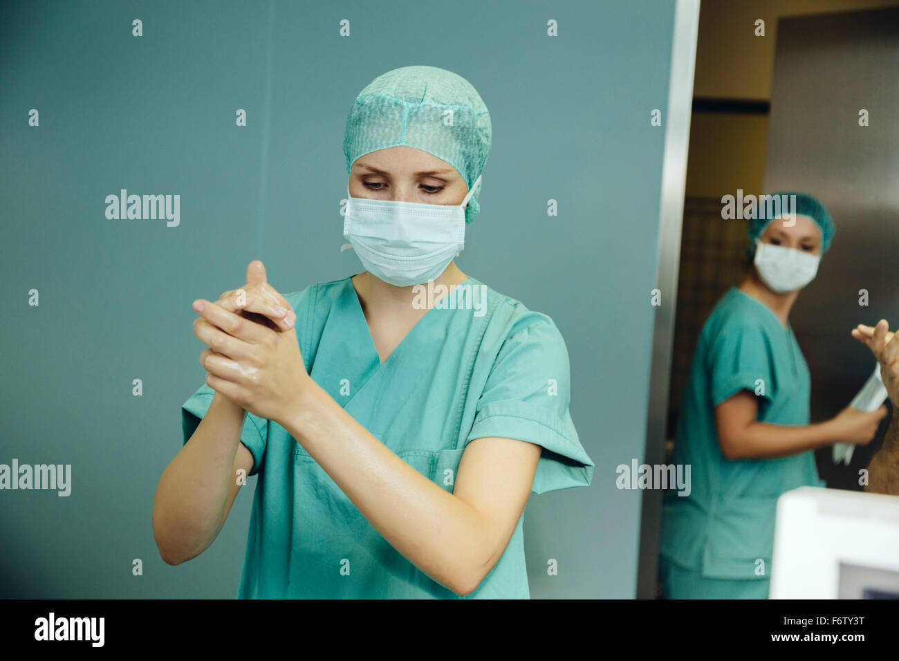 Chirurgo femmina la disinfezione delle mani prima di un intervento chirurgico Foto Stock