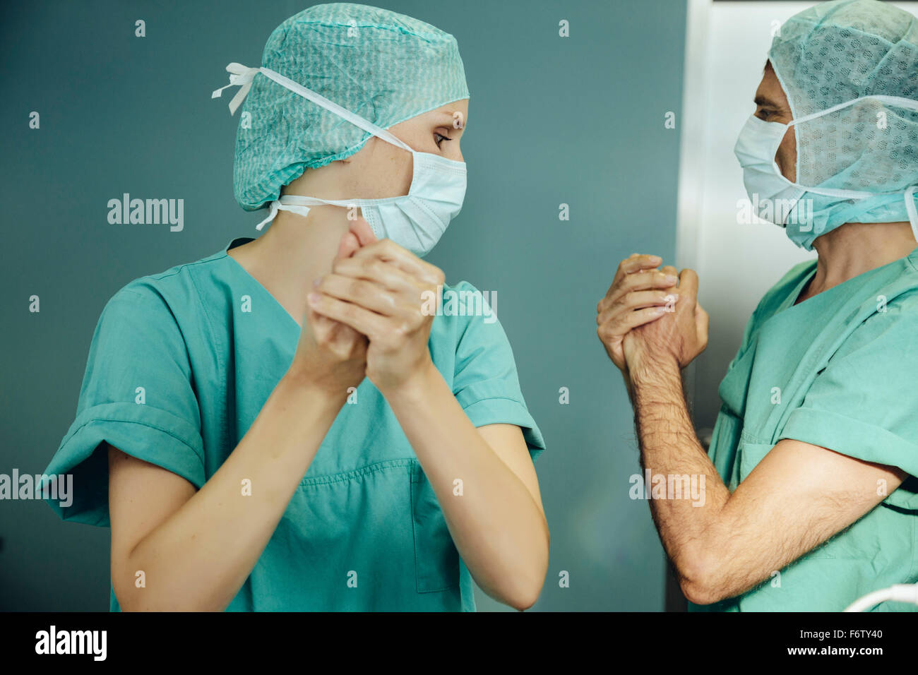 Due chirurghi disinfettare le mani prima di un intervento chirurgico Foto Stock