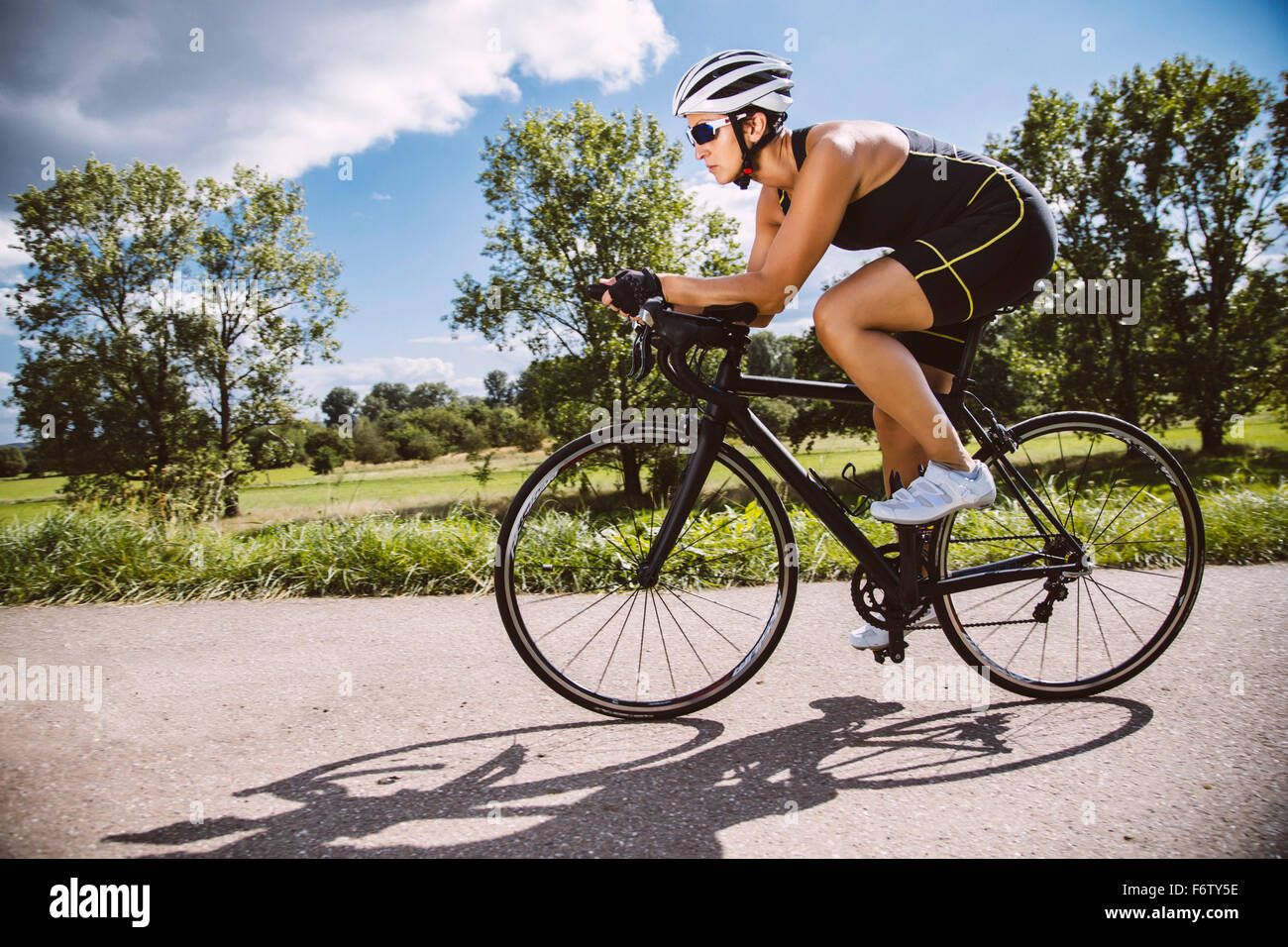 Triatleta femmina cavalcare la sua bici da corsa Foto Stock