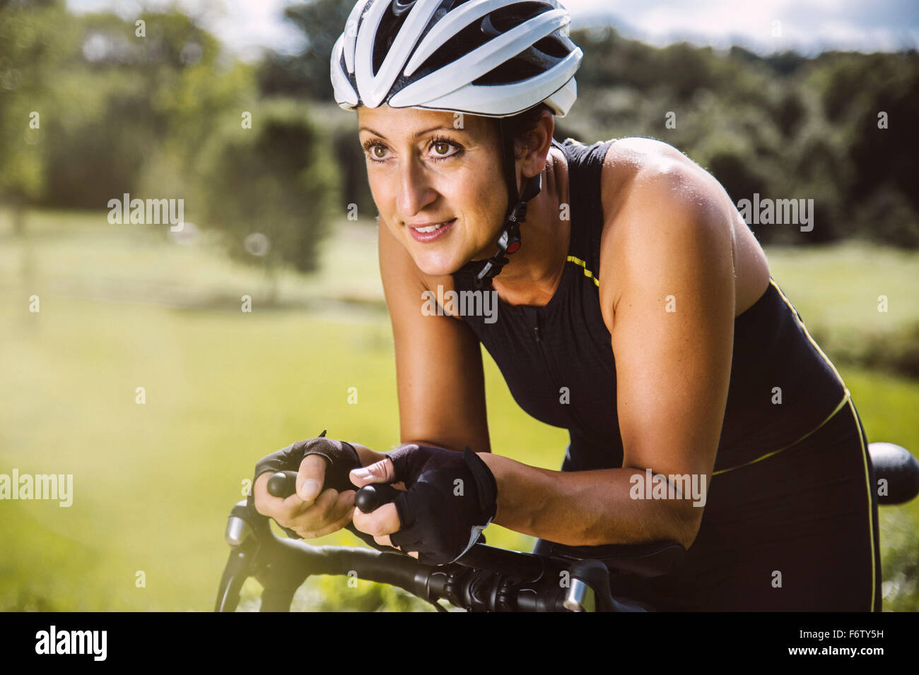 Triatleta femmina cavalcare la sua bici da corsa Foto Stock