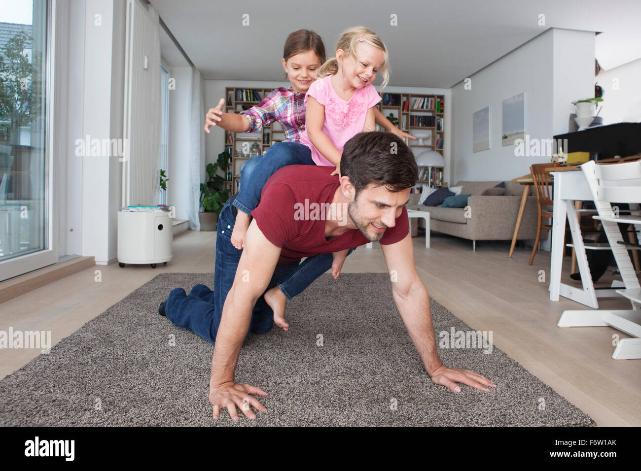 L'uomo gioca con il suo piccolo figlie nel soggiorno Foto Stock