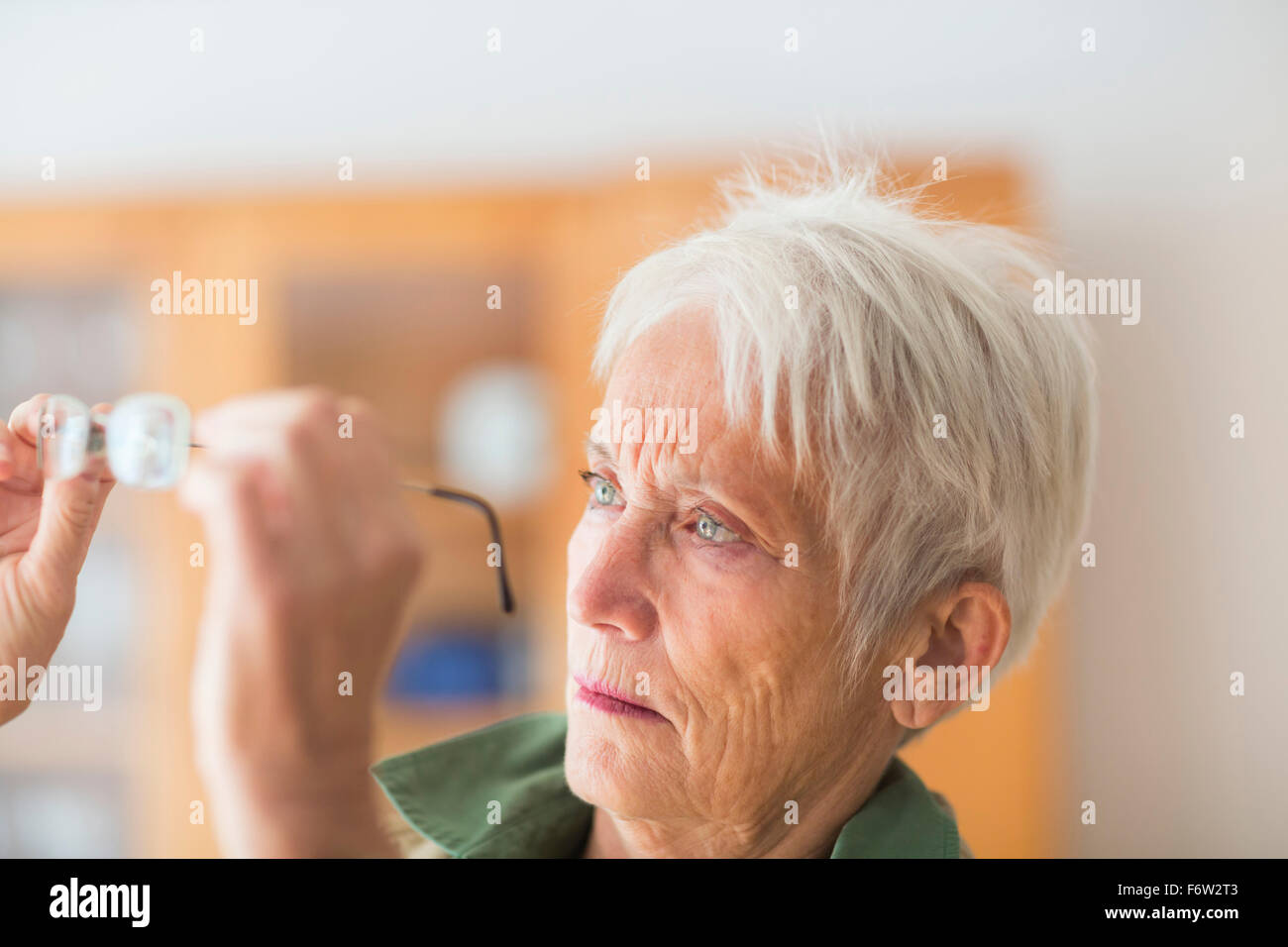 Ritratto di capelli bianchi senior donna guardando gli occhiali Foto Stock