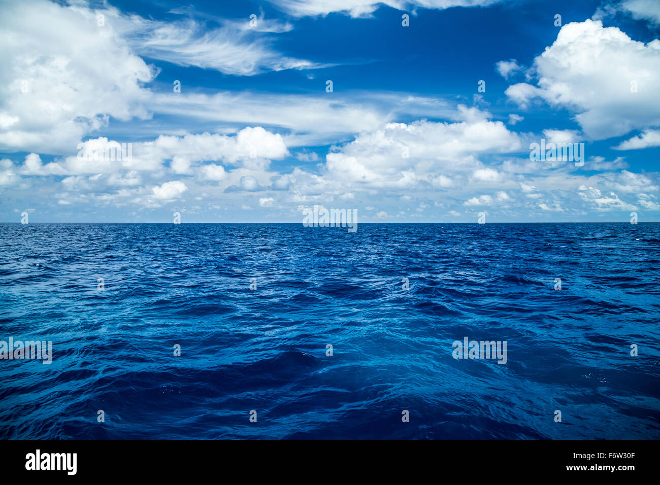 Vista sul mare blu profondo di fronte blu cielo molto nuvoloso Foto Stock