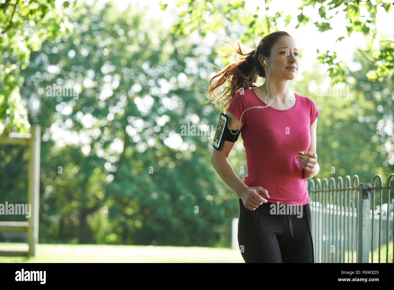 Femminile nel parco con tecnologia indossabile Foto Stock