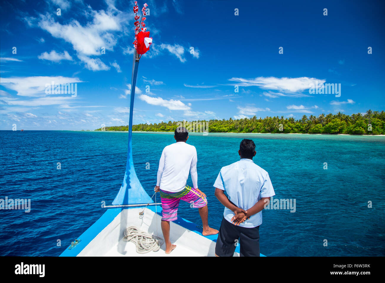 Guide su un maledivian dhoni boot guardando la costa Foto Stock