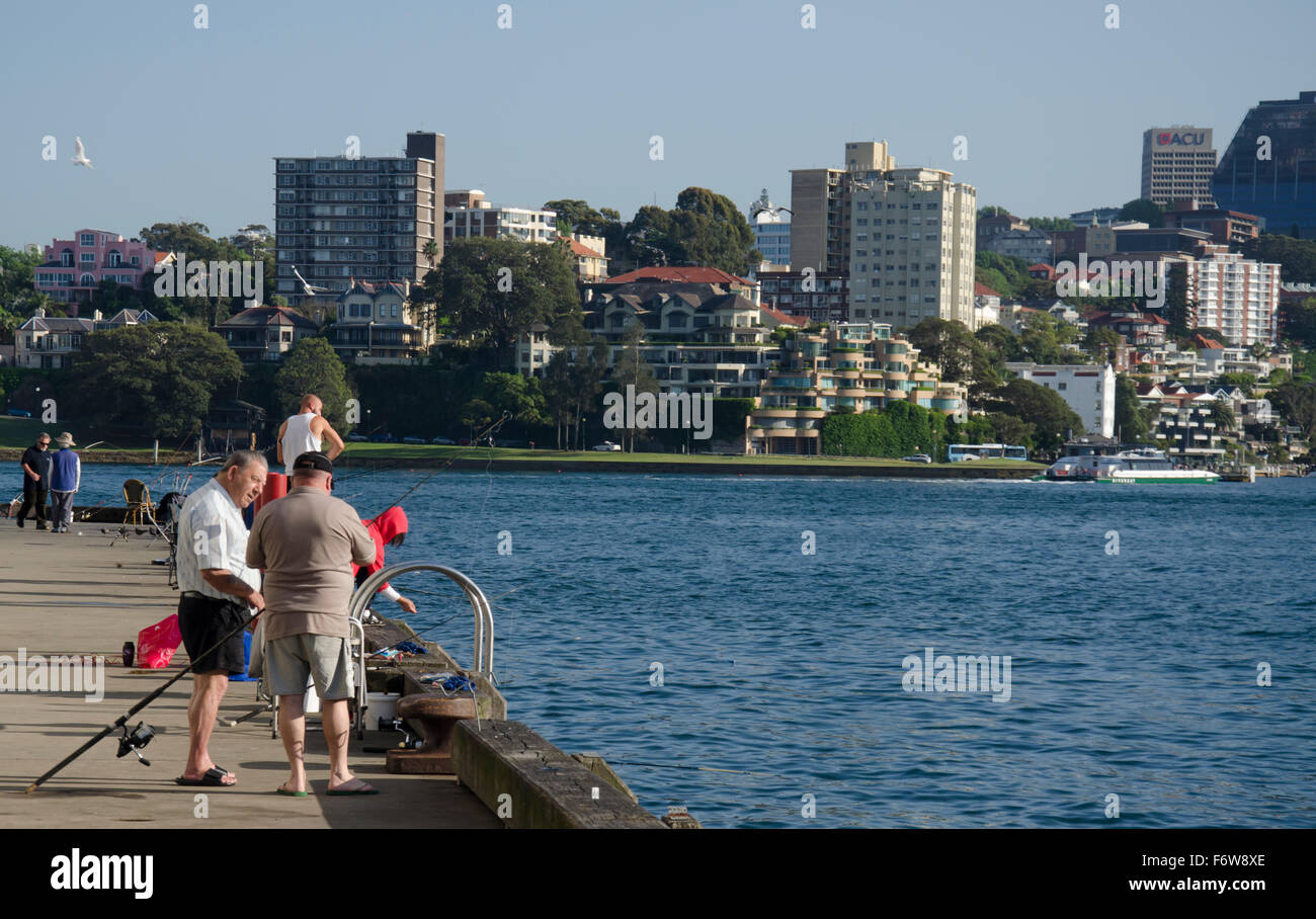 Gli uomini più anziani che parlano e che pescano su un wharf del dito a. Walsh Bay sul porto di Sydney in Australia Foto Stock