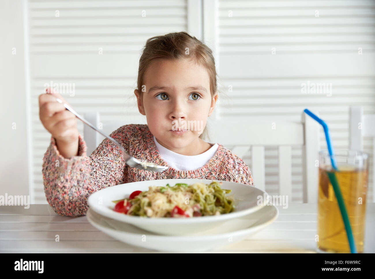 Bambina mangiare pasta per la cena al ristorante Foto Stock