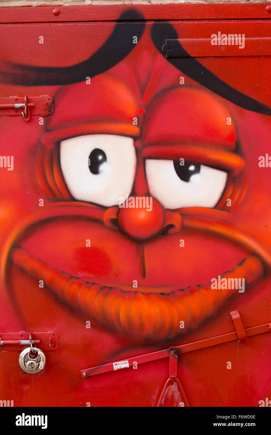 Regno Unito, Inghilterra, nello Yorkshire, Hull, Mercato della Frutta, Humber Street, faccia rossa graffiti sullo sportello posteriore della casa di fumo Foto Stock