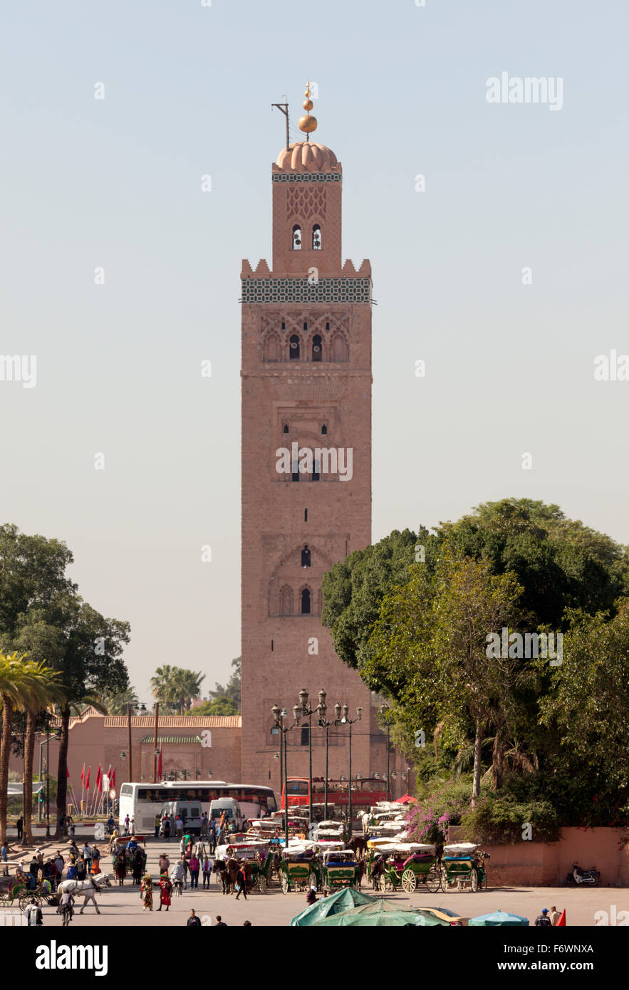 Marrakech, minareto della moschea Kotoubia e carrozze trainate da cavalli in attesa in linee, vista da Djemaa el Fna Foto Stock