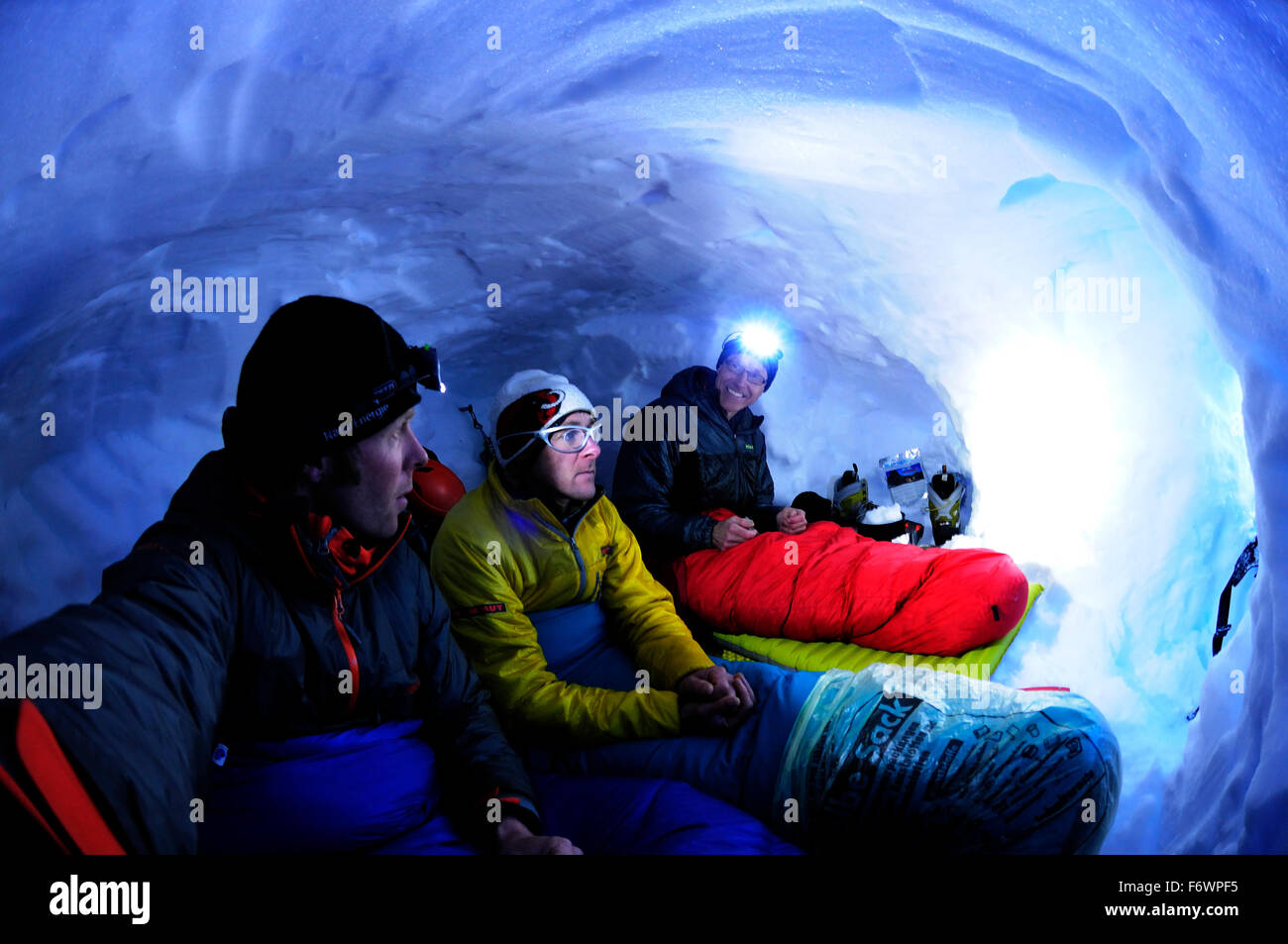 Tre alpinisti bivouacking in una grotta di neve a Collado Este, Monte Sarmiento, Cordillera Darwin, Tierra del Fuego, Cile Foto Stock