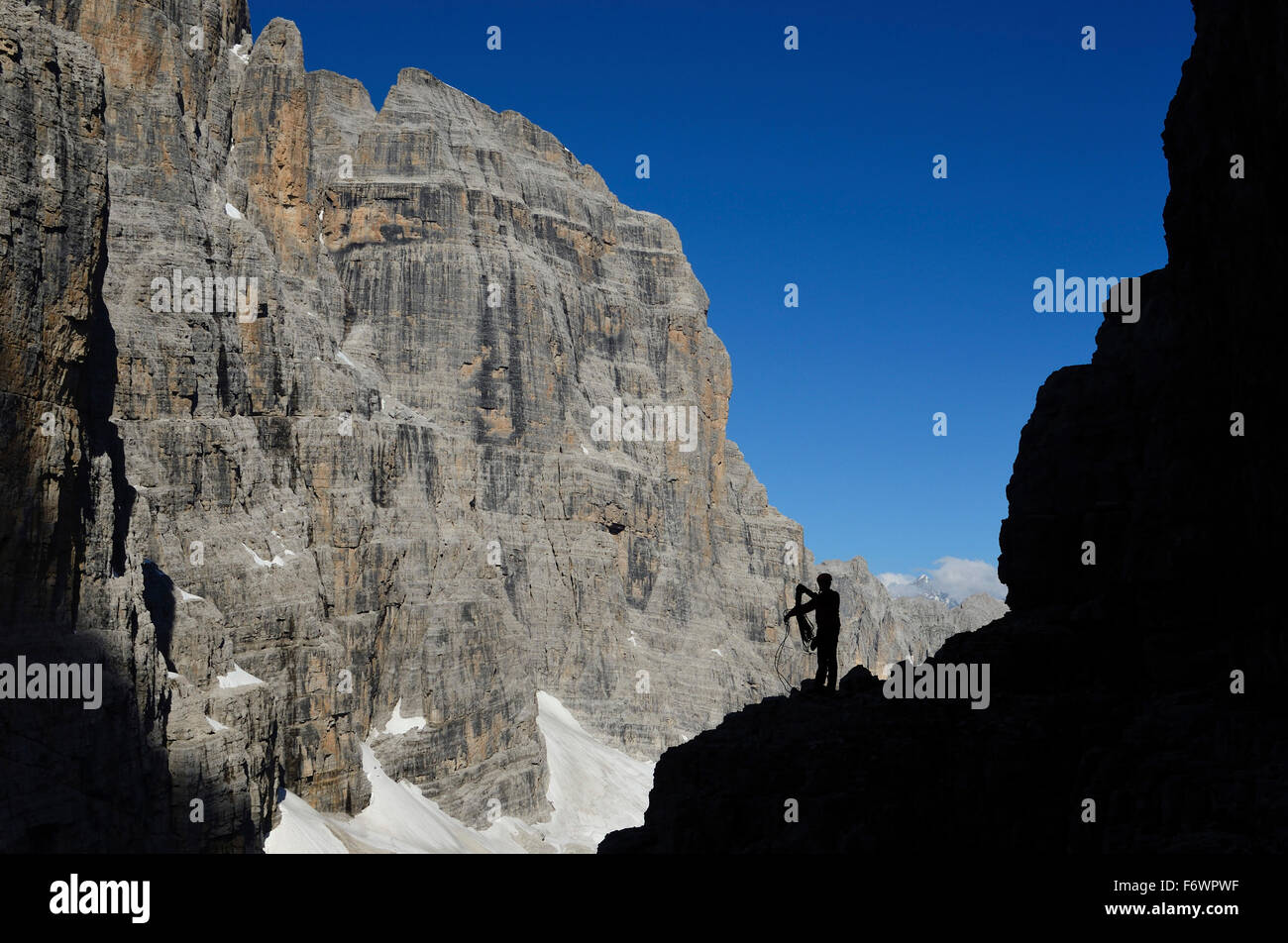 Scalatore ai piedi del Campanile Basso, Crozzon di Brenta in background, Trentino, Italia Foto Stock