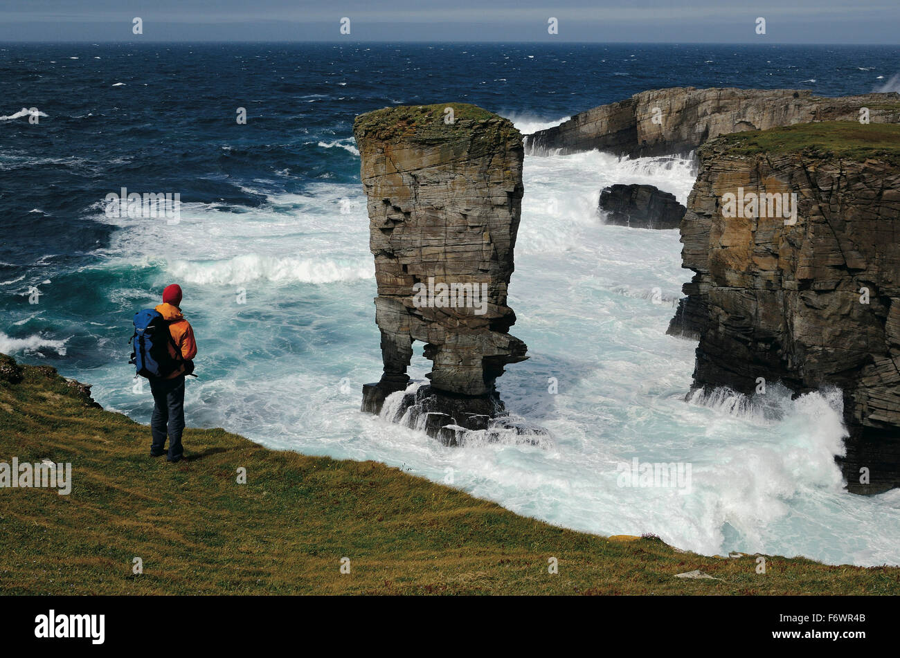 Escursionista guardando al castello di Yesnaby, Continentale, isole Orcadi Scozia, Gran Bretagna Foto Stock