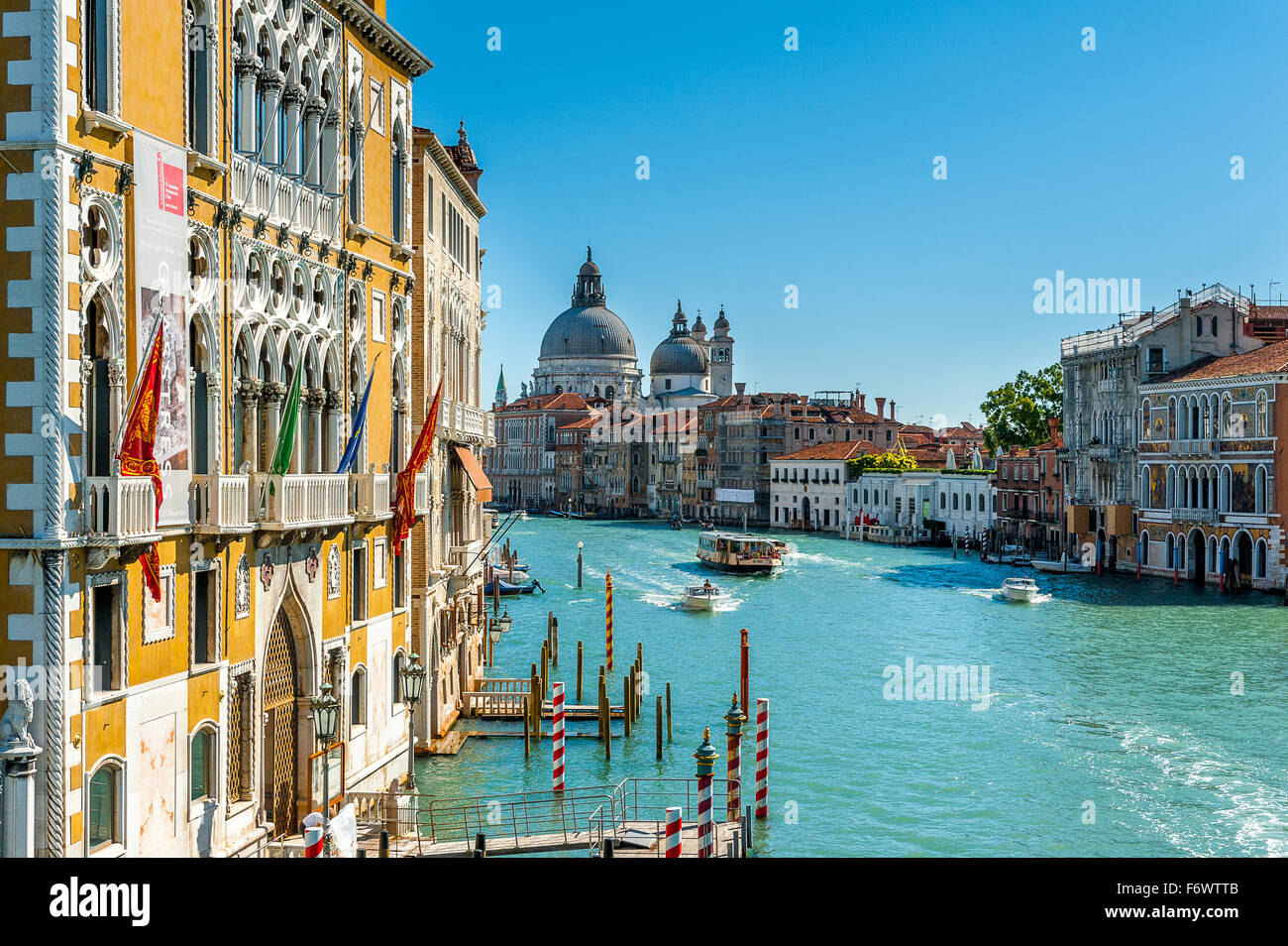 Splendida vista delle barche sul Canal Grande a Venezia con Santa Maria della Salute in background. Foto Stock