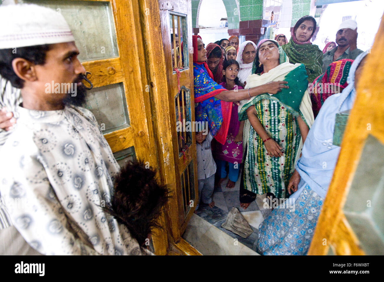 Un ossessa all'ingresso del mazaar Shah Shamshudin o Hayrat Shah Baba Dargah , n.a. , Gujarat. La centrale area sacra contenente i resti è noto come il mazaar le donne siano vietate l'entrata a causa della loro percezione di 'inquinato ' stato cos dei periodi e simili. Shah Shamshudin o Hayrat Shah Baba Dargah , n.a. , Gujarat. shoot Data 05 - 08 Maggio 2010 Foto Stock