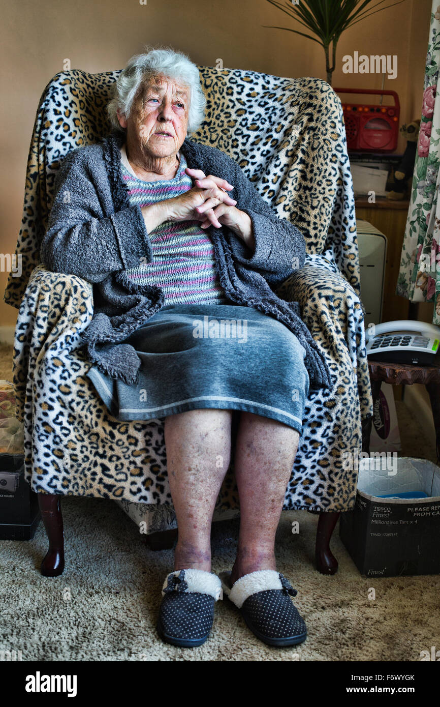 Una vecchia signora seduta su una sedia Foto Stock