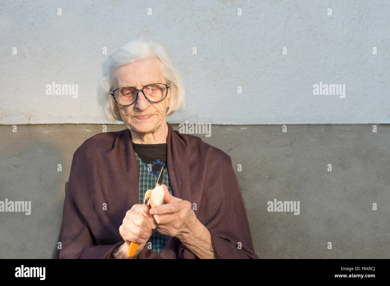 Novanta anni nonna la tranciatura e la sfogliatura di un Apple Foto Stock