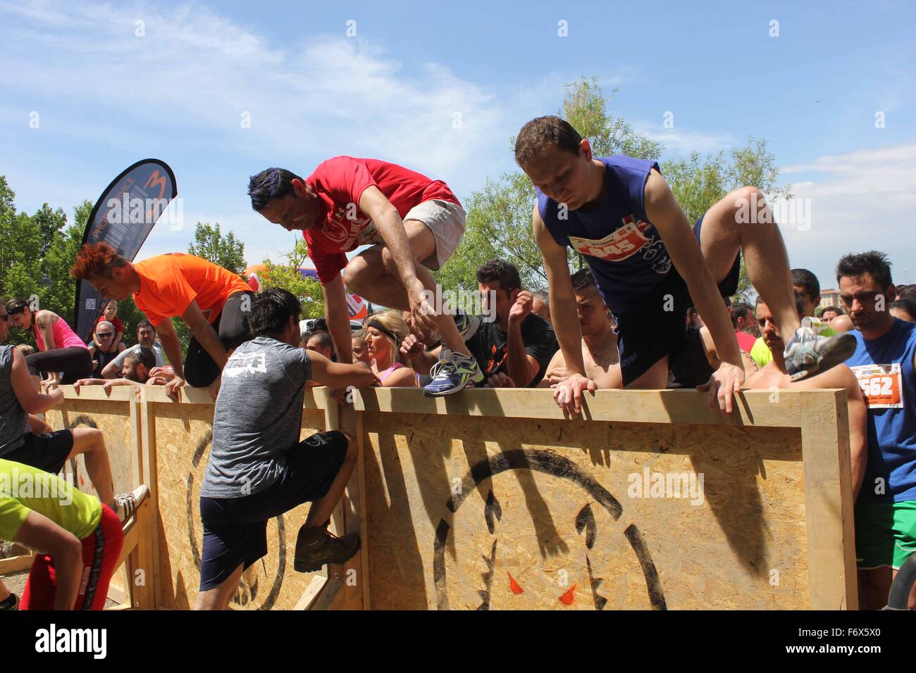 SIGNA, Italia - 9 Maggio 2015: il gruppo di persone che saltano su un ostacolo durante l'Inferno Run gara di fango a Firenze Foto Stock