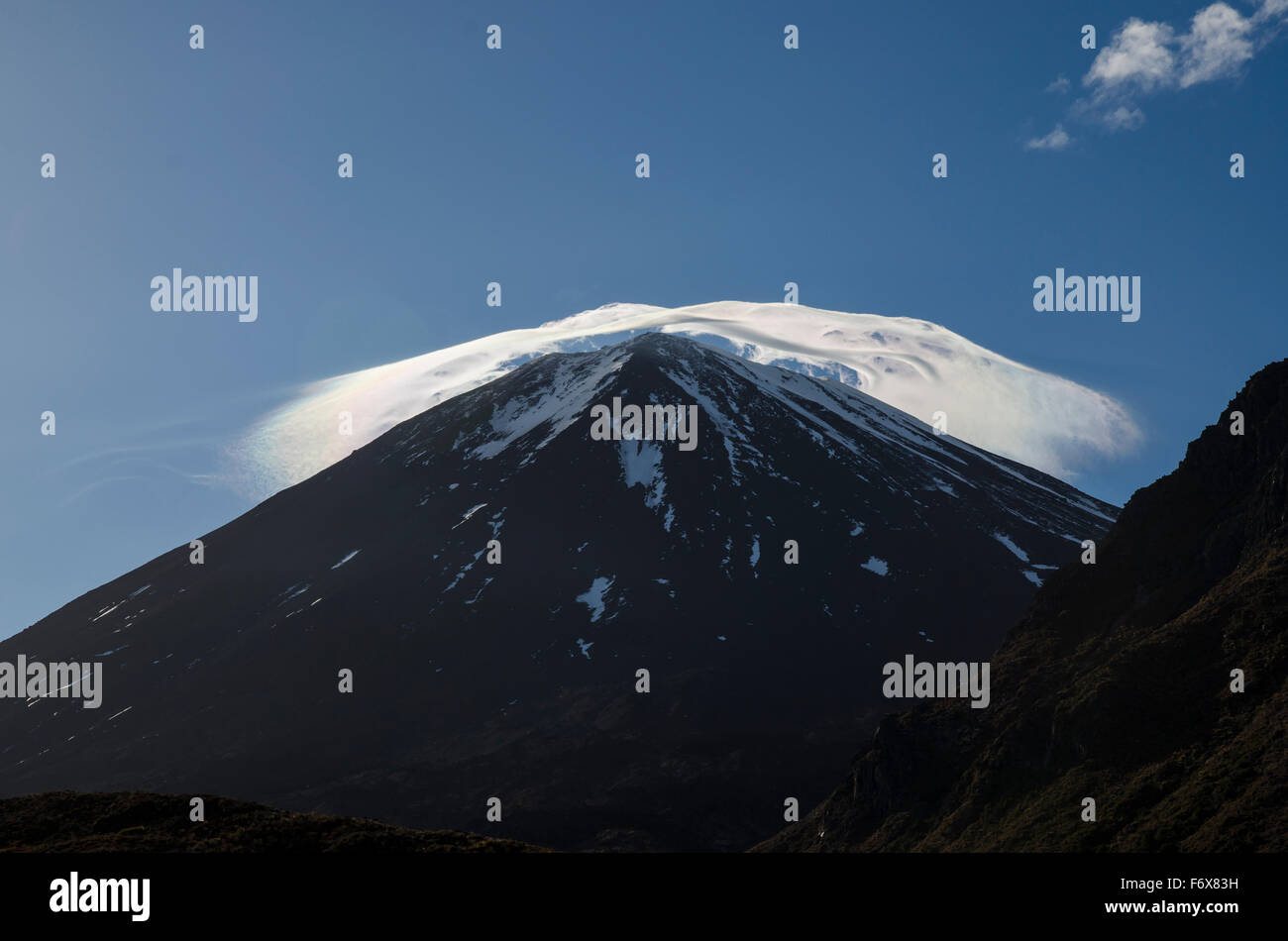 Un tappo del cloud illuminata dal sole che sorge sulla sommità del monte Ngauruhoe, Tongariro Crossing; Nuova Zelanda Foto Stock