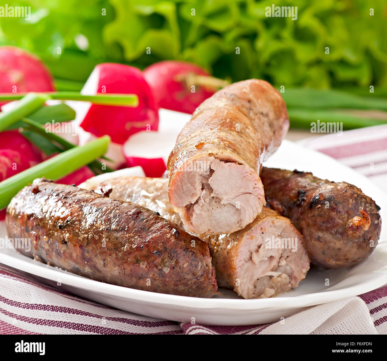 Salsicce fatte in casa cotto al forno e insalata mista Foto Stock