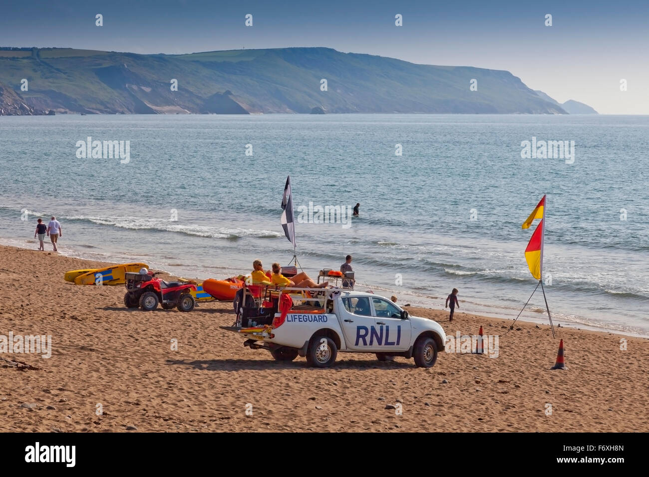 RNLI bagnini sulla spiaggia di Widemouth Bay assicurandosi che i surfisti e i nuotatori sono sicuri, Cornwall, Regno Unito Foto Stock