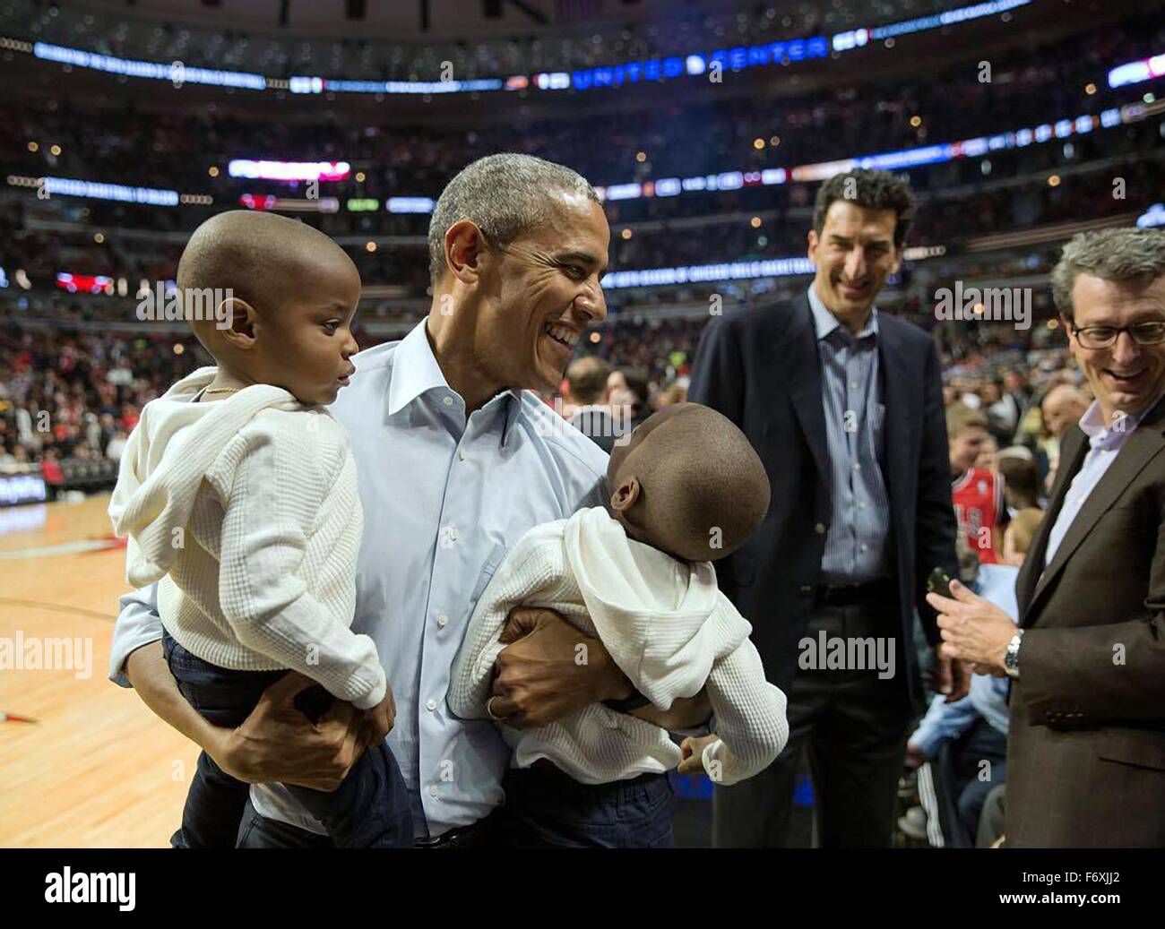 Stati Uniti Il presidente Barack Obama detiene due ragazzi in posa per una foto con loro durante il tempo di emisaturazione del Chicago Bulls-Cleveland Cavaliers gioco di basket presso la United Center Ottobre 27, 2015 a Chicago, Illinois. Foto Stock