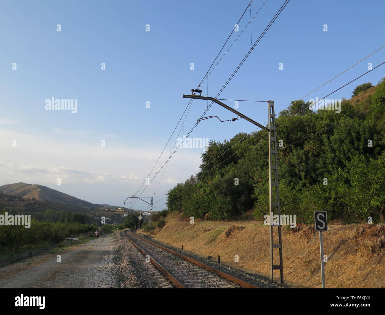 I binari della ferrovia e strada di campagna sulla giornata soleggiata vicino a Alora, andalusia Foto Stock