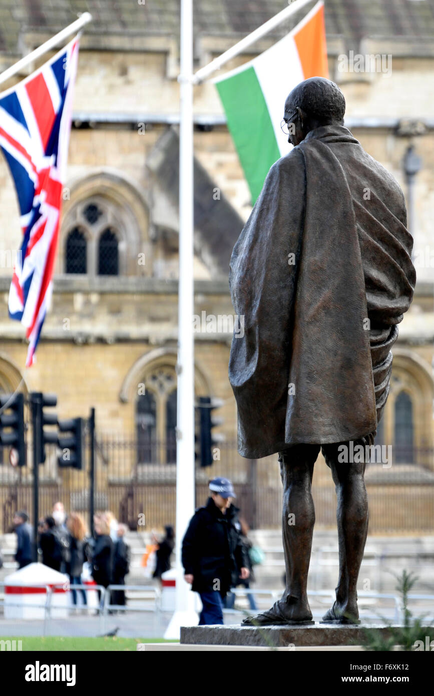 Londra, Inghilterra, Regno Unito. Statua del Mahatma Gandhi, Piazza del Parlamento. (2015: Philip Jackson) con indiani e bandiere britanniche Foto Stock