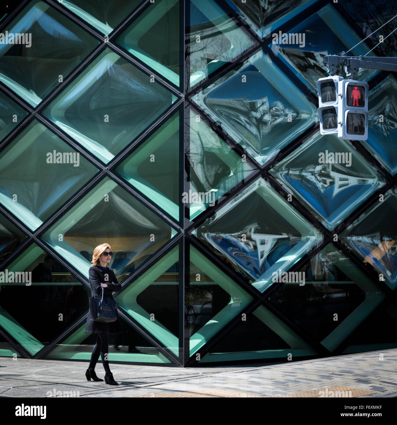 Moda donna fuori la geometrica vetri del negozio Prada nel trendy quartiere Aoyama di Tokyo Foto Stock