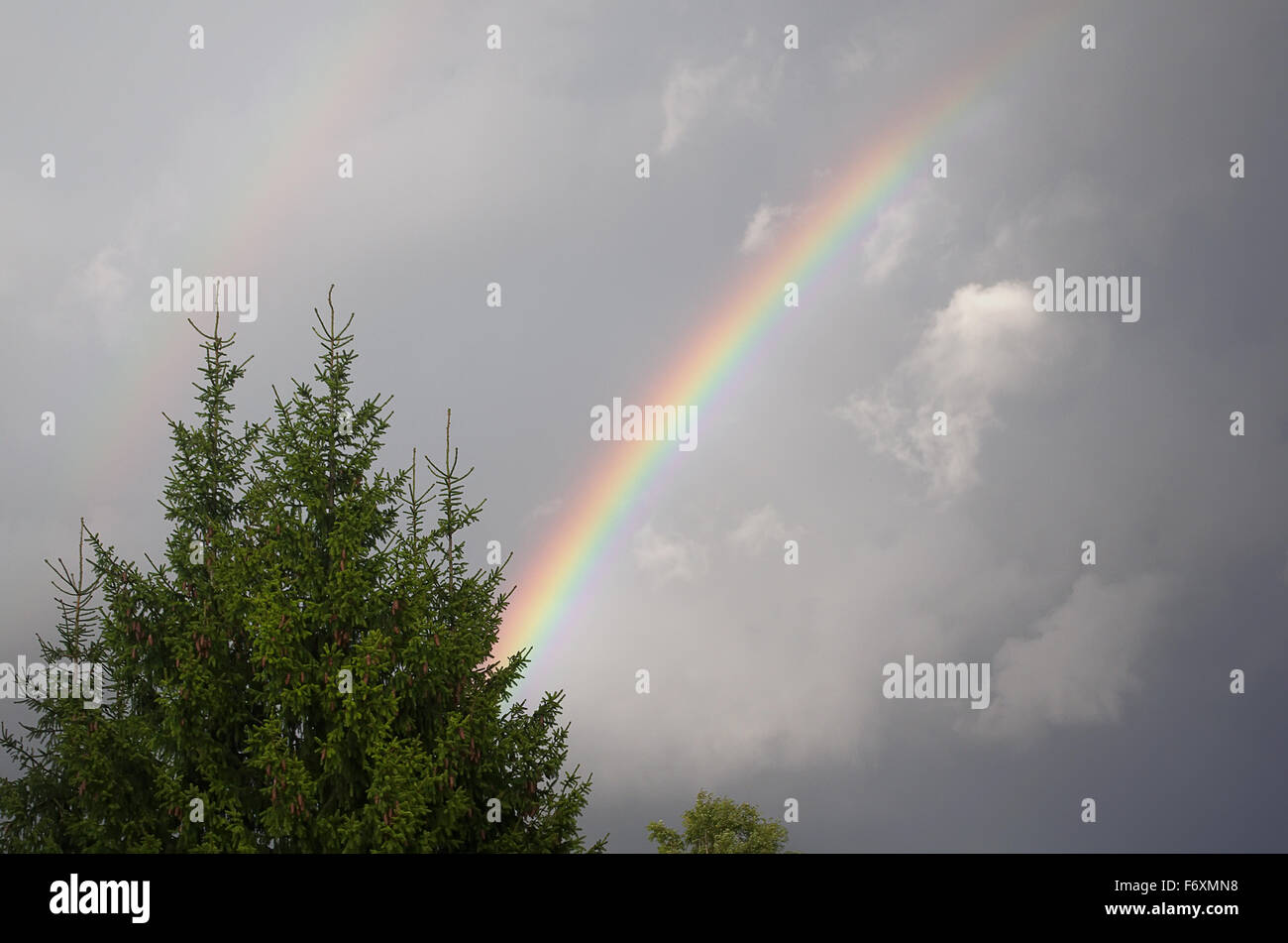 Rainbow in grigio le nuvole in cielo. Foto Stock