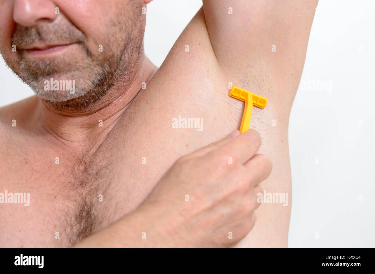 L'uomo la rasatura i peli sotto la sua ascella con un palmare rasoio, in  prossimità del suo le ascelle e la mano Foto stock - Alamy