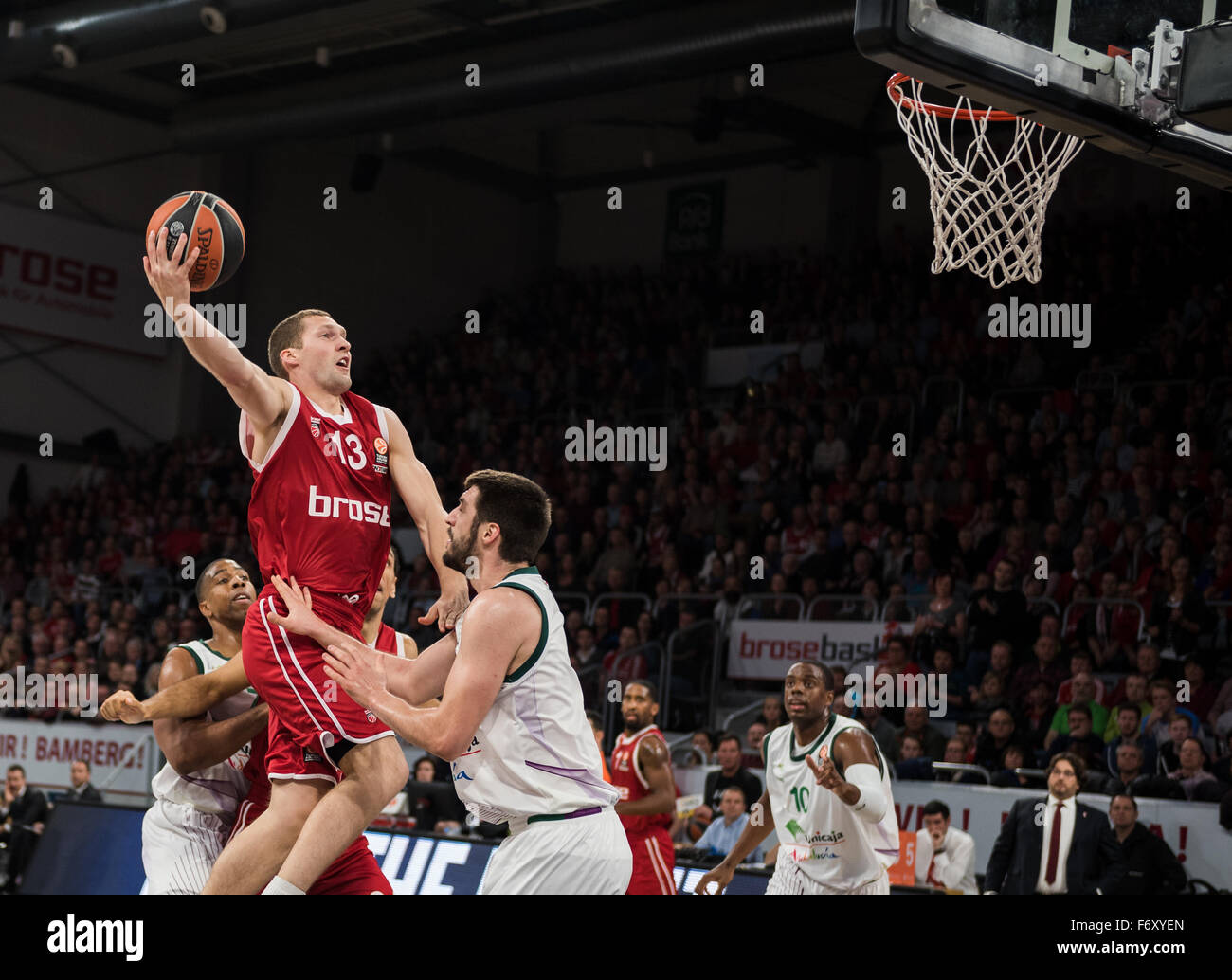 Bamberg, Germania. Xx Nov, 2015. Bamberg's Janis Strelnieks (top) in azione contro Malaga's Richard Hendrix (l) e Stefan Markovic (2.f.r.), durante il gruppo di Eurolega di basket D match tra cesti Brose Bamberg e Unicaja Malaga a Bamberg, Germania, 20 novembre 2015. Foto: NICOLAS ARMER/DPA/Alamy Live News Foto Stock