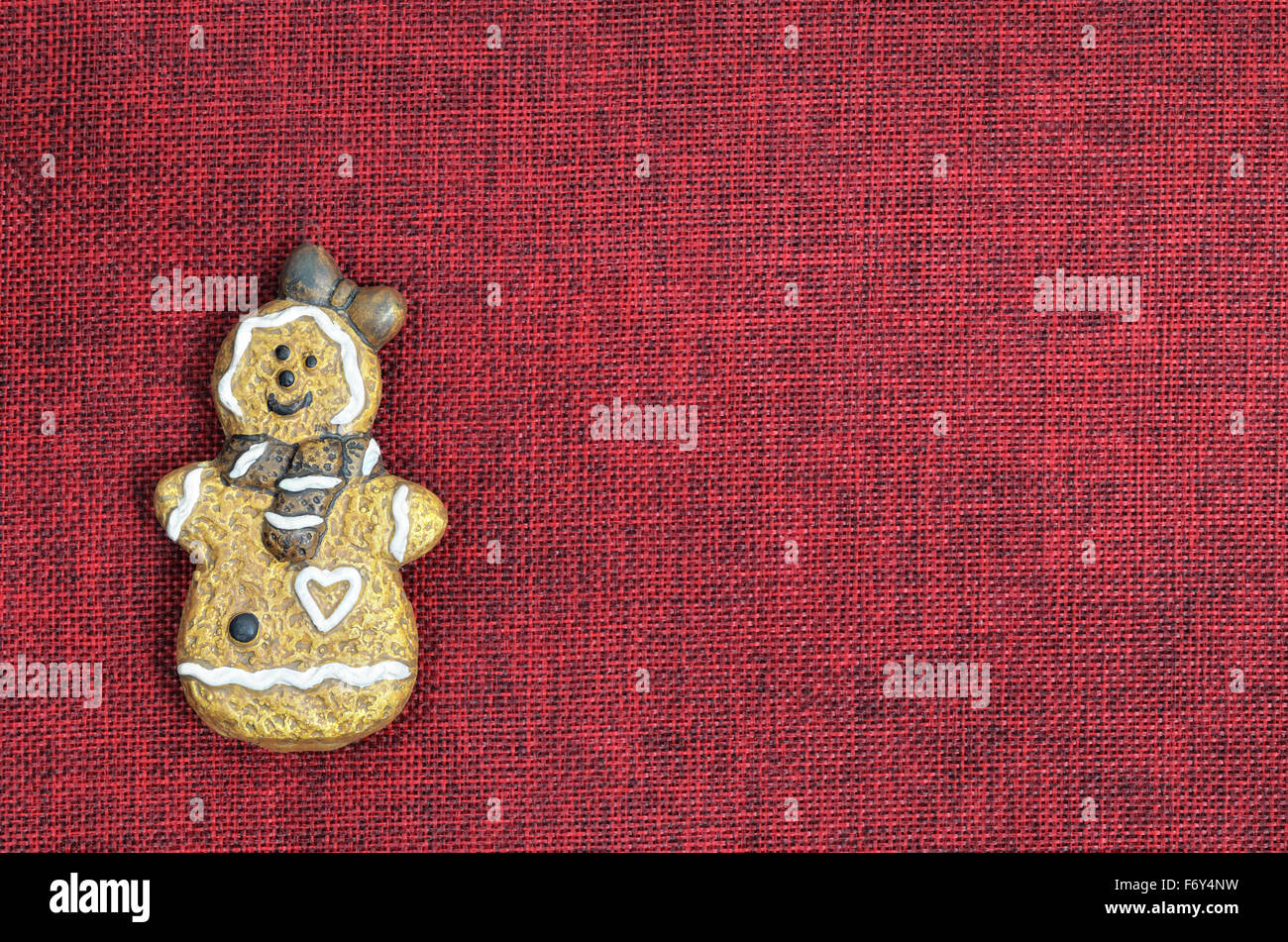 Close up di un cookie di Natale , donna, sorridente, su tela rossa con spazio copia, orizzontale Foto Stock