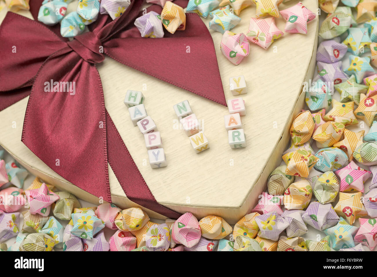 Parola felice anno nuovo sulla confezione regalo con origami lucky stelle Foto Stock