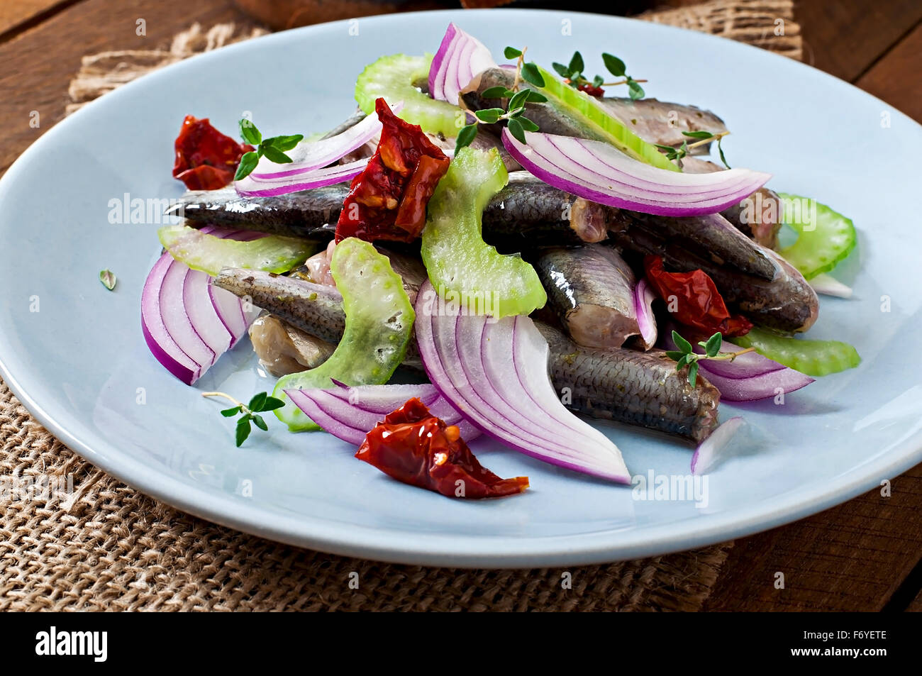 Aringa con insalata di pomodori secchi, il sedano e la cipolla rossa Foto Stock