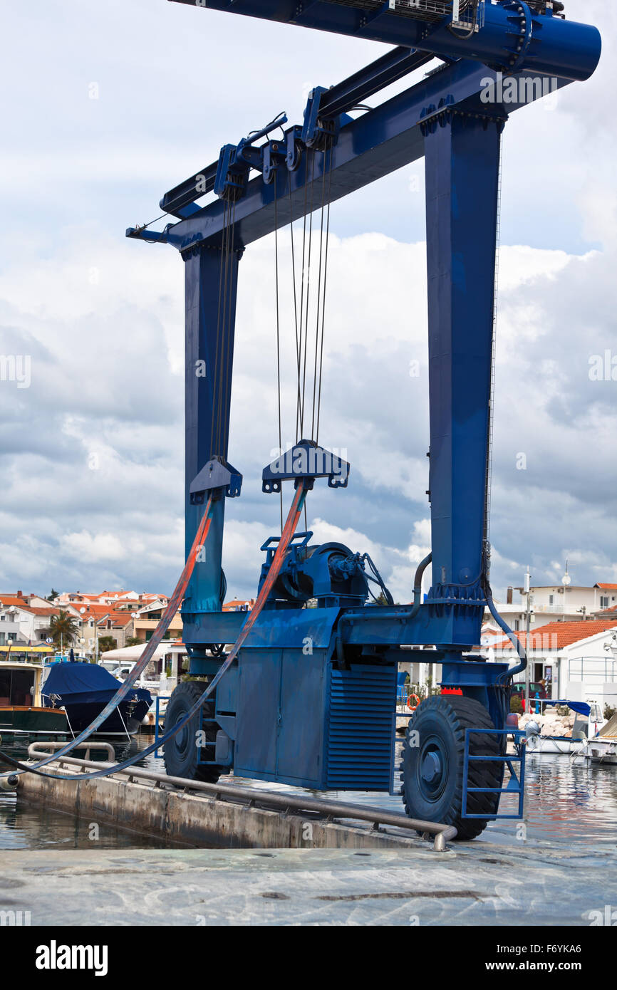 Gru grande per una manutenzione della nave in un porto turistico. Colpo verticale Foto Stock