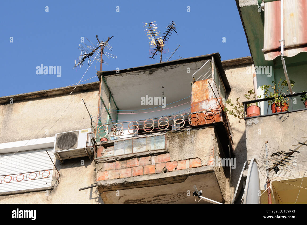 Un insicuro cercando balcone su un vecchio edificio. Tirana, Albania. Foto Stock