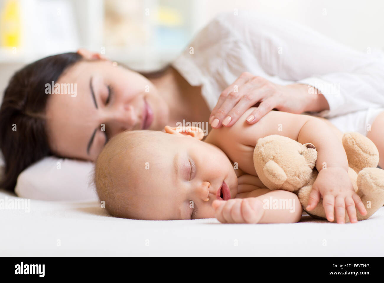 Bella donna e bambino dormono insieme in una camera da letto Foto Stock