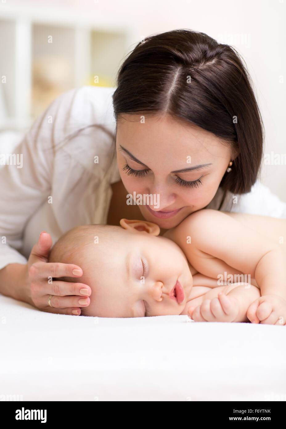 Donna felice guardando il figlio che dorme baby Foto Stock