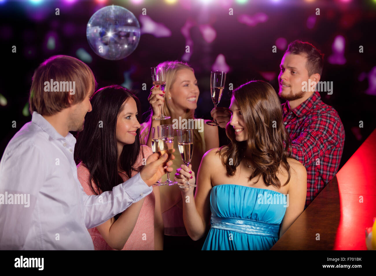 Felice giovani tintinnanti con champagne in discoteca. Foto Stock
